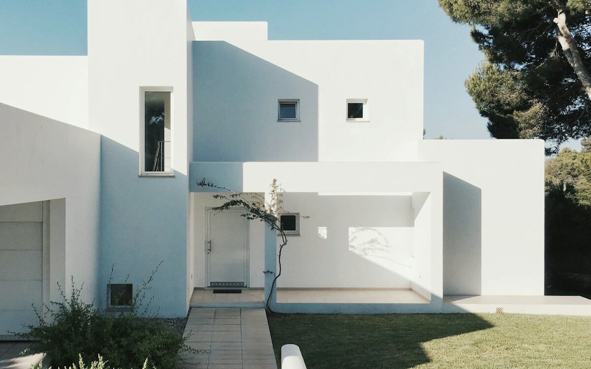 white concrete house near green tree during daytime