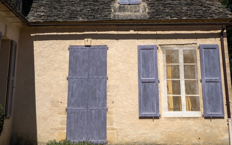 a house with blue shutters and a brown roof